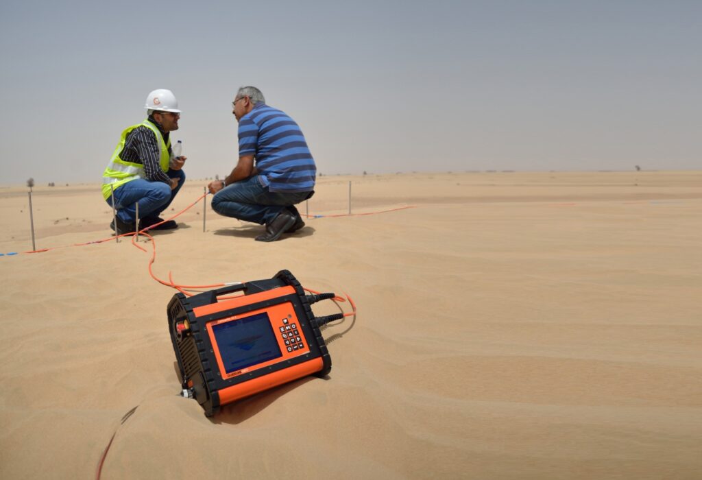 Geophysical survey team conducting electrical resistivity tomography (ERT) and subsurface investigation in a desert environment using advanced geophysical equipment.