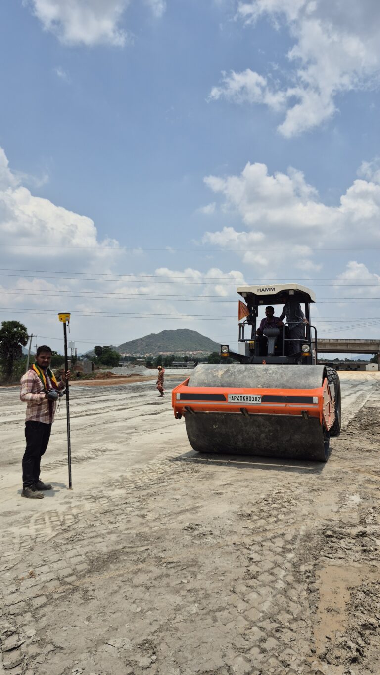 Road roller and survey equipment on construction site