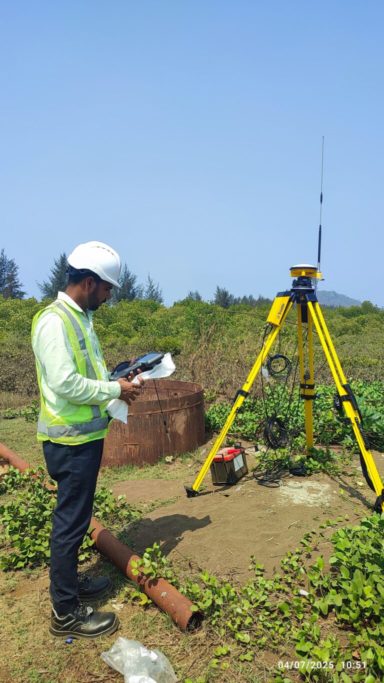 Survey engineer operating a Trimble GNSS receiver for RTK positioning and control point establishment at a field survey site.